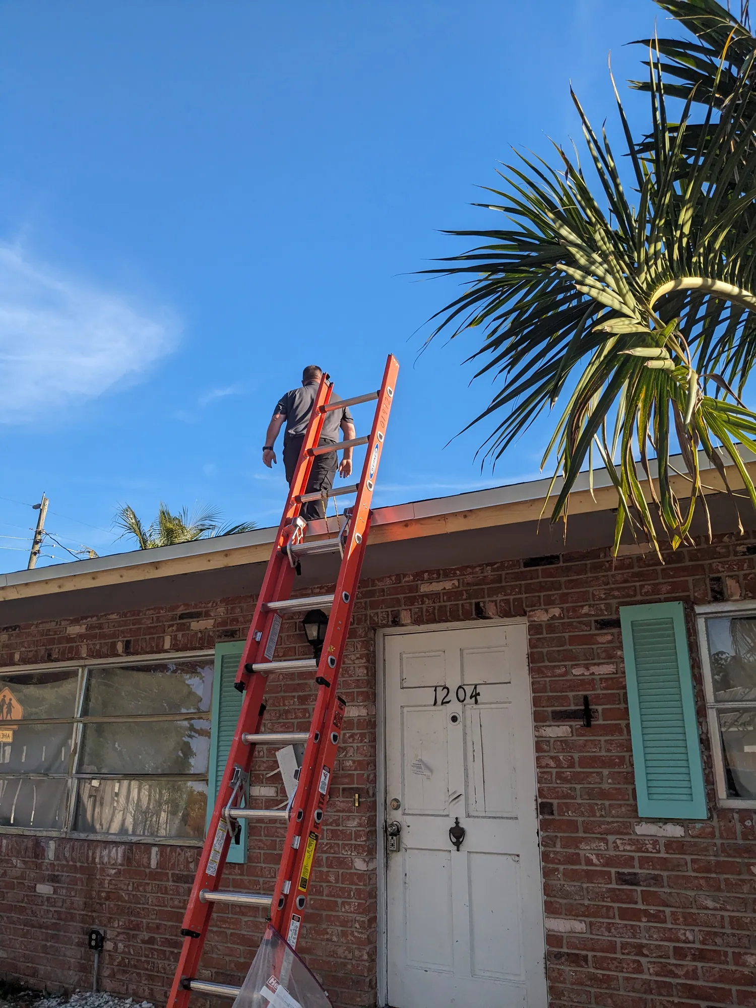 DR Construction & Roofing crew finishing a brown shingle roof on a South Florida home